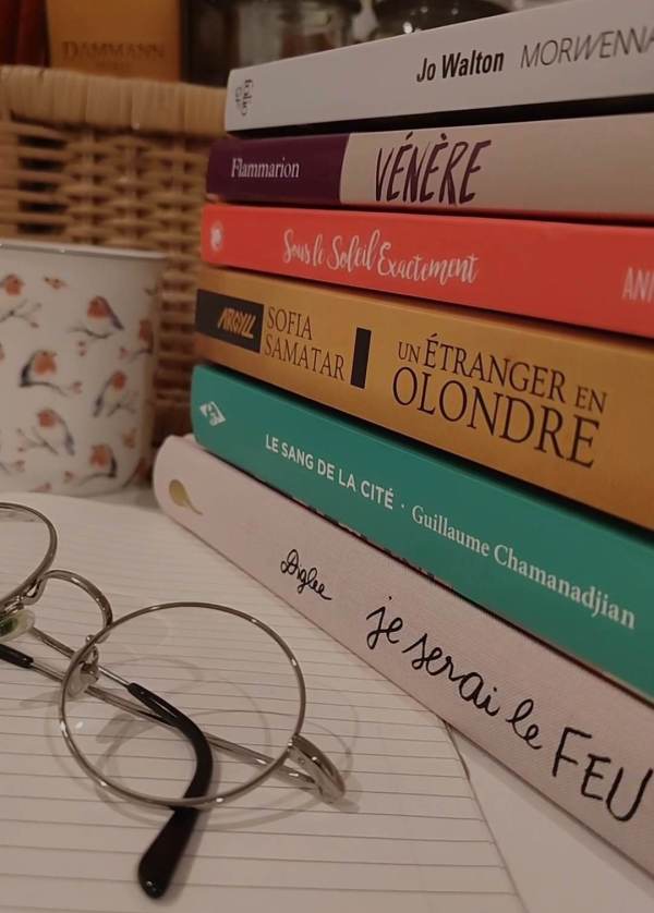 Photo d'une pile de livres avec une paire de lunettes rondes